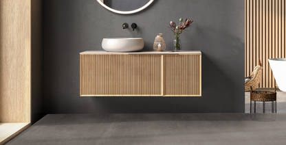 Stylish bathroom featuring ETRON Mikromono 15 kg microcement flooring and modern wooden vanity with sink.